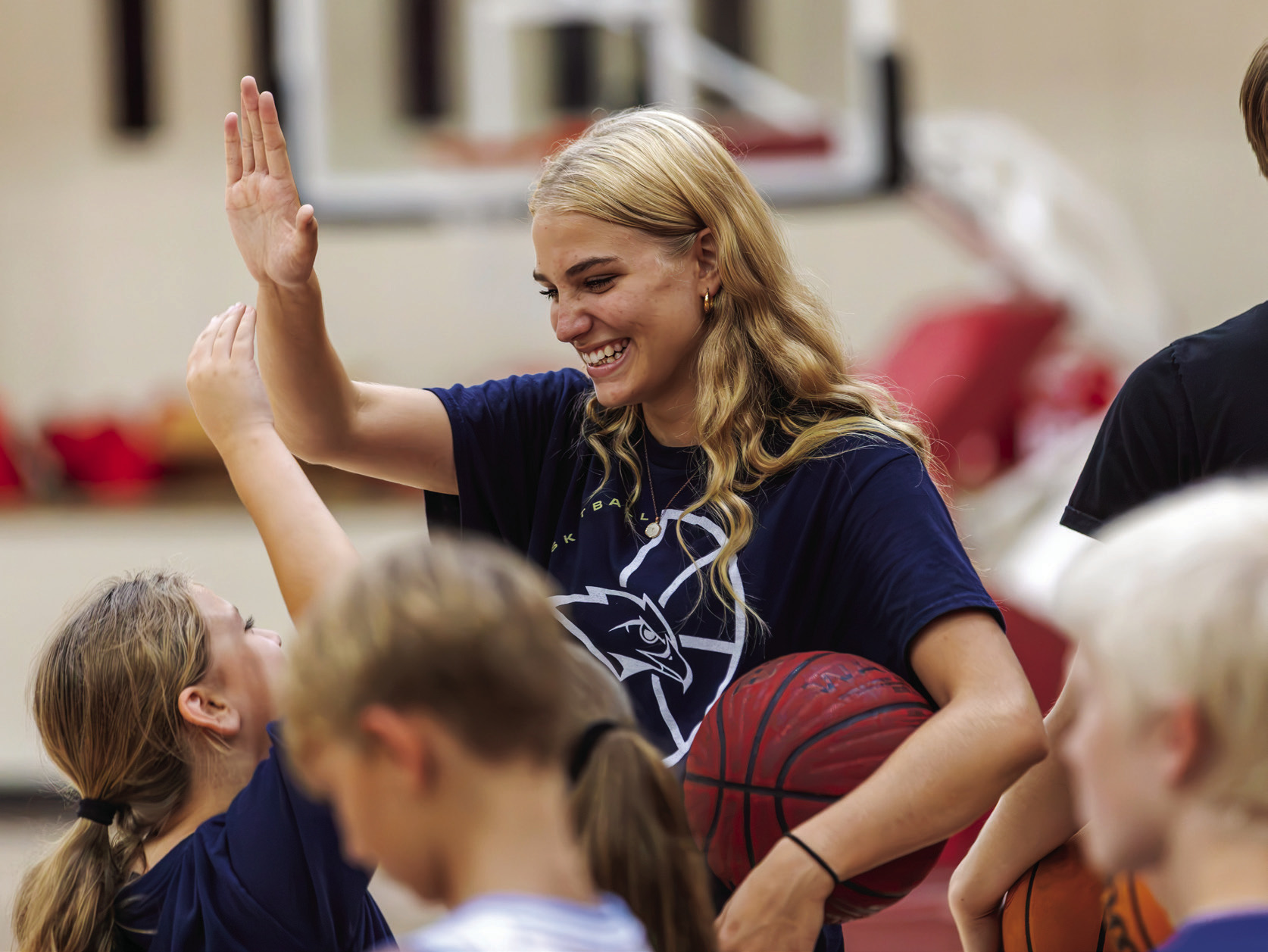 Lady Tiger leader Payge Schaefer high fives a camper during the Cleveland Tiger Future Star basketball camp. Photo by John Burns. See inside for more photos.