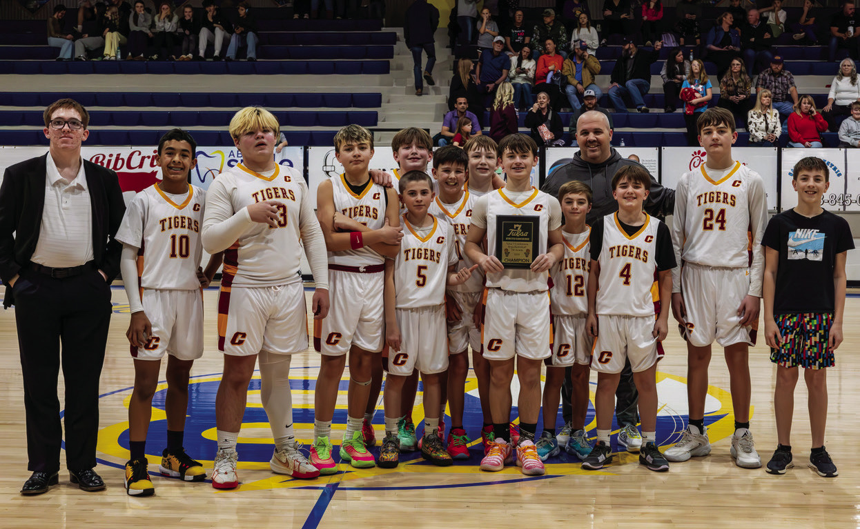 The Cleveland Middle School seventh-grade basketball team celebrates after defeating Mannford to claim the Tulsa 7 District Championship. Photo by John Burns.