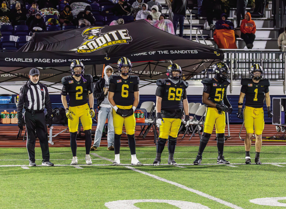 The Charles Page Sandite captains for last Friday’s game against Putnam City walk on to the field. They are, Dominic Forbes, Easton Webb, Michael Mears, Shawn Hatcher and Alex Dudley. The Sandites staged a dramatic come-from-behind win to edge out the Pirates 27-26. See story, Page 4. Photo by John Burns