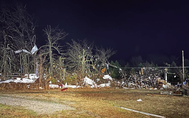 Debris hangs in trees along a rural fence line in Creek County after a tornado moved through the area.