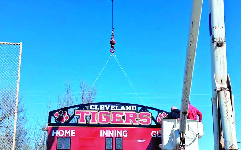 A bucket truck from Freedom Tree Service lifts a new scoreboard into place at the Cleveland baseball fields. The company donated equipment and time to help install the scoreboard, improving the game-day experience for players, families and fans.