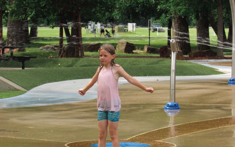 Arya Linquist anxiously awaits a bucket dump at the Super Splash Park located in Case Community Park while she was there with family and friends last week. Photos by DeAnna Maddox